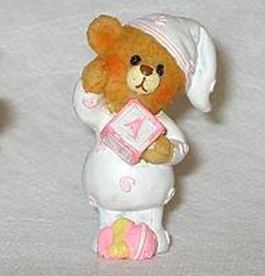 Une figurine en résine ourson rose et blanche pour la décoration de table d'un baptême fille
