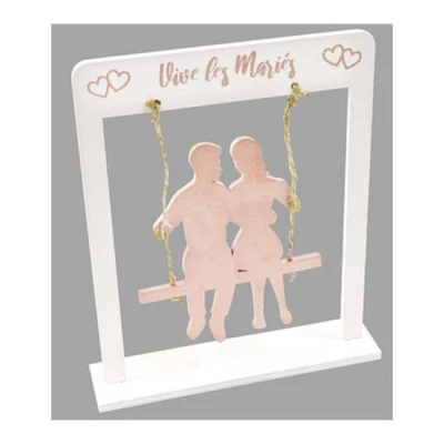 Un cadre en bois sur support coloris blanc avec au centre un couple de mariés sur une balancoire coloris rose gold