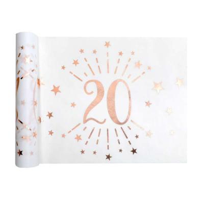 5 Mètres chemin de table anniversaire 20 ans en intissé, fond blanc, impression du chiffre 20 et d'étoiles rose gold métallisé.