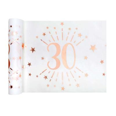 5 Mètres chemin de table anniversaire 30 ans en intissé, fond blanc, impression du chiffre 30 et d'étoiles rose gold métallisé.