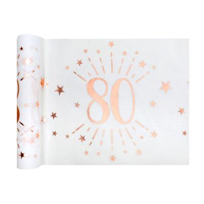 5 Mètres de chemin de table anniversaire 80 ans en intissé, fond blanc, impression du chiffre 80 et d'étoiles rose gold métallisé.