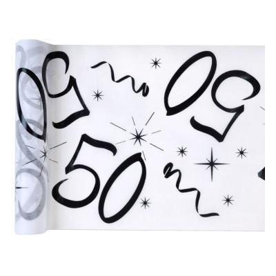 Un chemin de table anniversaire, intissé fond blanc avec le chiffre 50 et des serpentins imprimés en coloris noir.