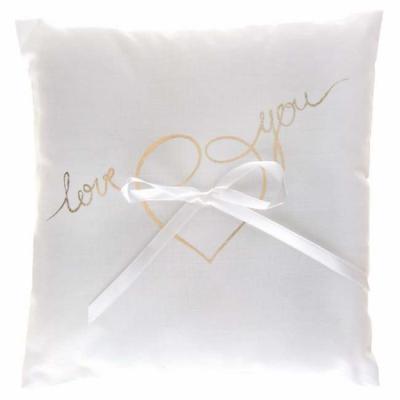 Un petit coussin en coton blanc avec ruban satin blanc portant l'inscription coloris Love You pour présenter les alliances