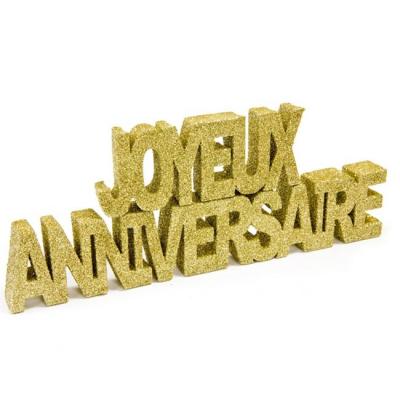 Les mots joyeux anniversaire écrits avec du polystyrène recouvert de paillettes or
