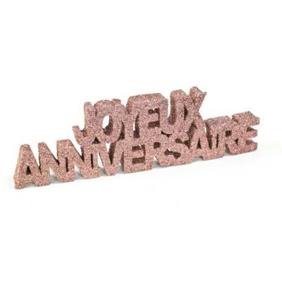 Les mots joyeux anniversaires écrits dans du polystyrène recouvert de paillettes fines rose gold