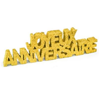 Les mots joyeux anniversaires écrits dans du polystyrène recouvert de paillettes fines or