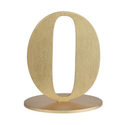 En bois coloris or, le chiffre 0 posé sur son  support à utiliser comme marque table ou en déco de table anniversaire