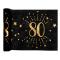 5 Mètres chemin de table anniversaire 80 ans en intissé, fond noir, impression du chiffre 80 et d'étoiles coloris or métallisé.