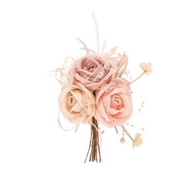 Un bouquet composé de 3 roses artificielles dégradé de rose, avec des perles et du ruban