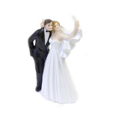 Une figurine en résine de 14 cm représentant un couple de mariésen train de faire un selfie.